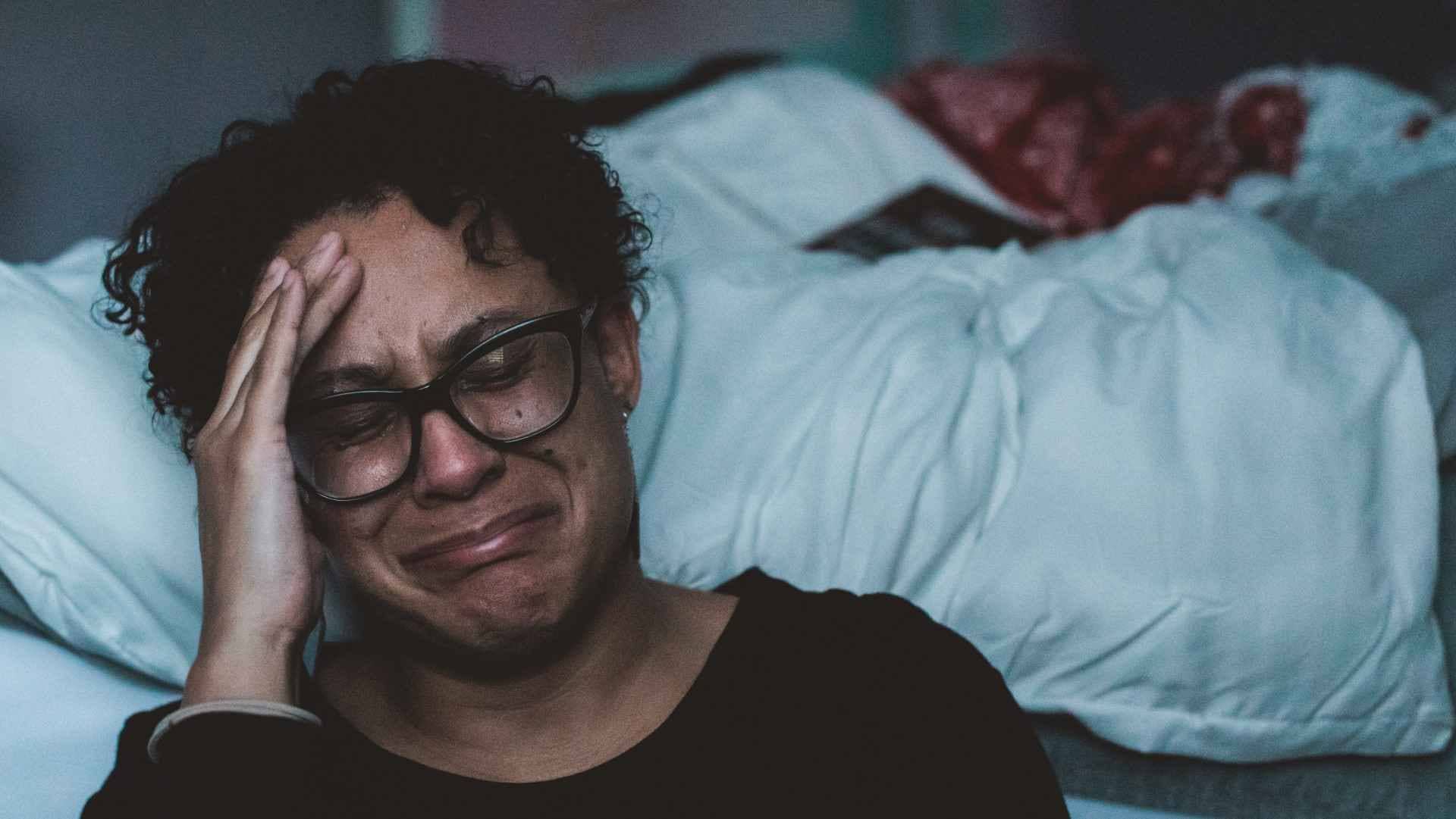 woman crying by her bed